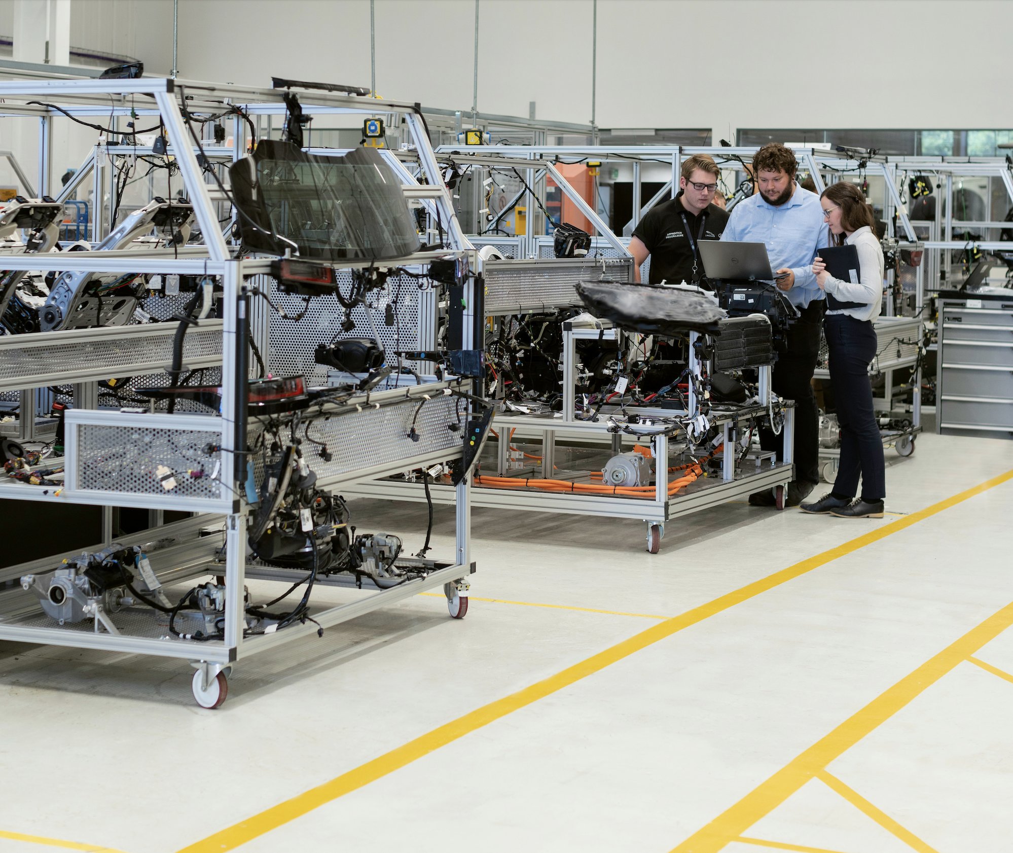 Engineers reviewing wiring harness assemblies on a manufacturing floor
