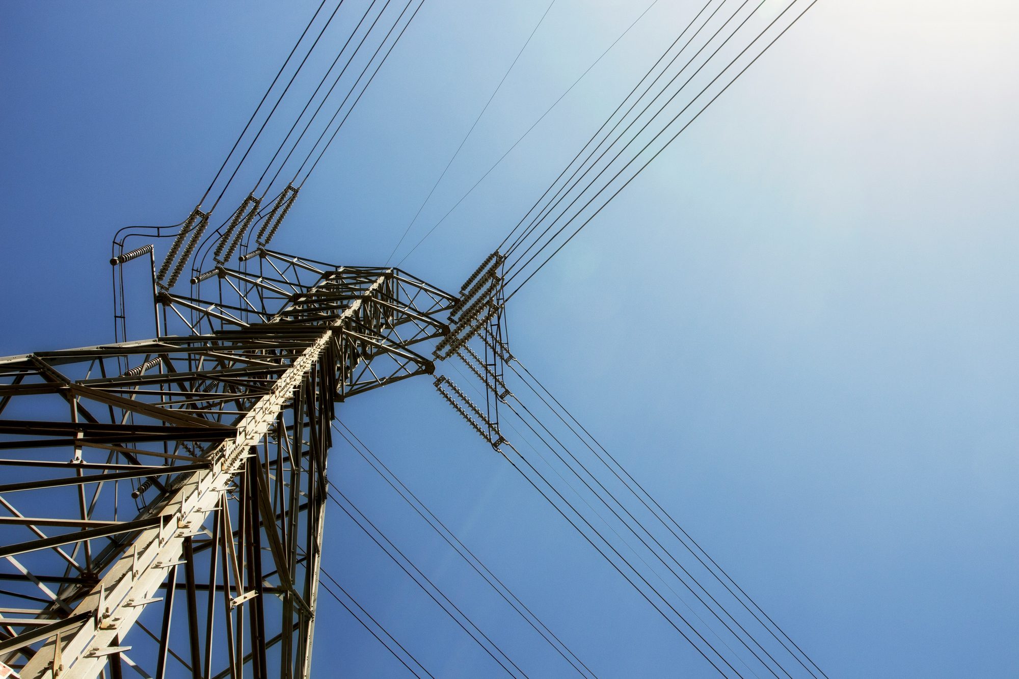 High-voltage transmission tower against blue sky