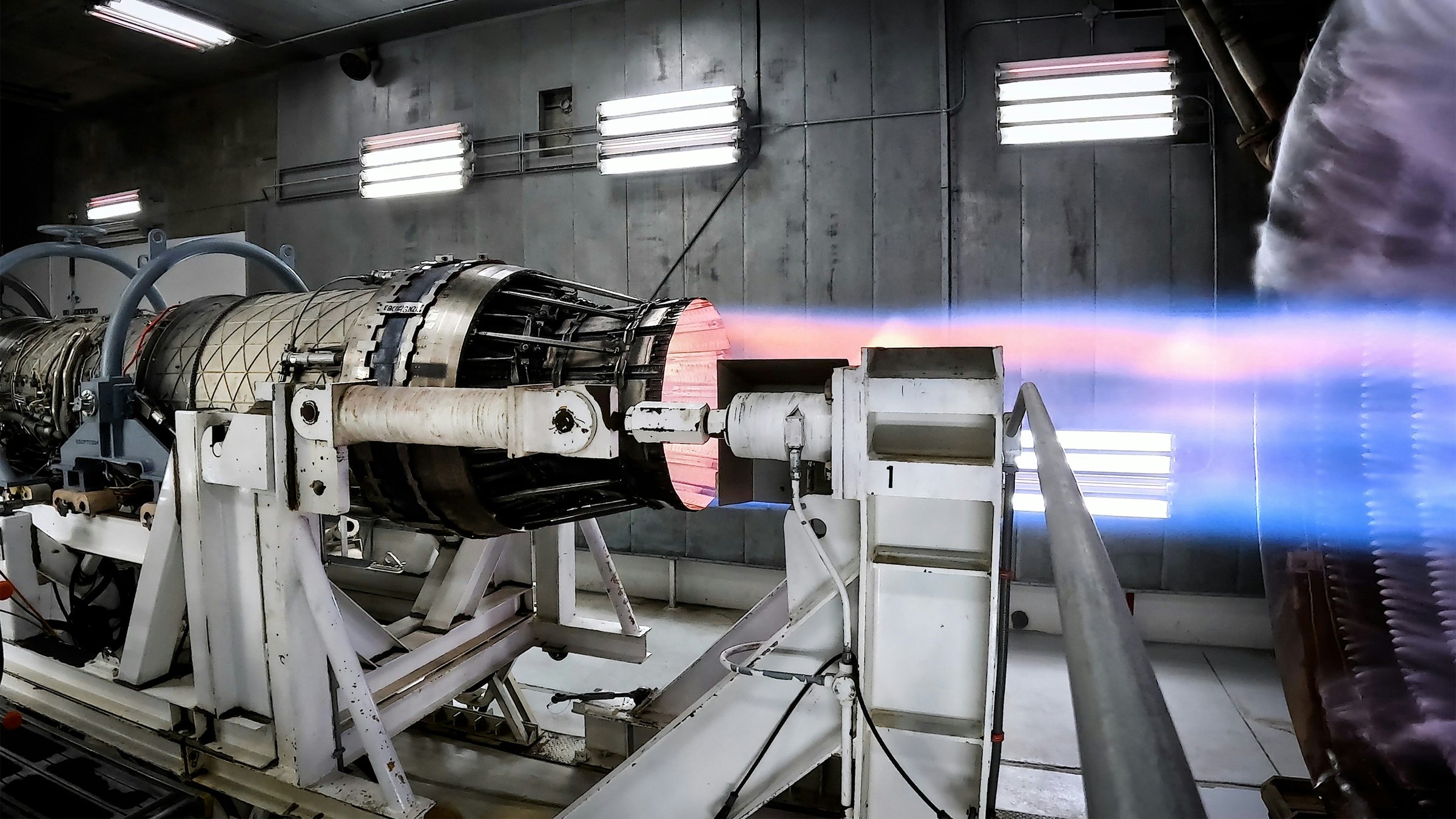 Jet engine on a test stand firing inside an industrial test facility