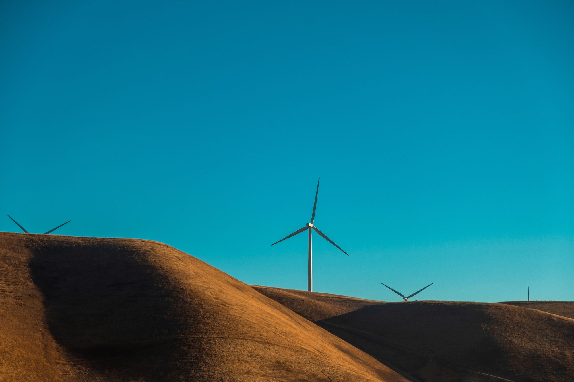 Wind turbines on rolling hills at golden hour